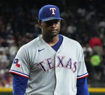 Texas Rangers pitcher Kumar Rocker walks off the field with a flat expression after the first inning.