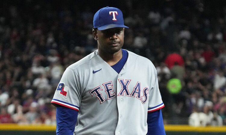 Texas Rangers pitcher Kumar Rocker walks off the field with a flat expression after the first inning.