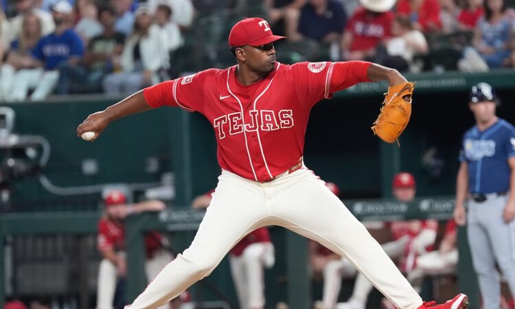 Texas Rangers right-hander Kumar Rocker, No. 80, strides toward the plate in a red Tejas jersey.