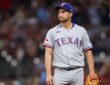 Texas Rangers catcher Kyle Higashioka purses his lips after allowing a hit while pitching.
