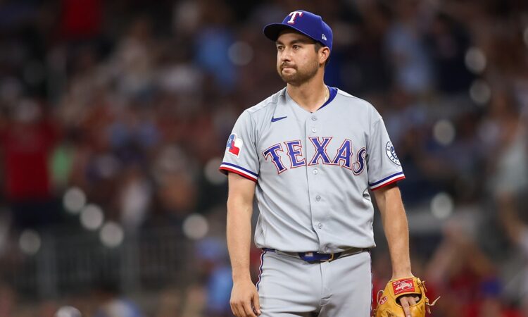 Texas Rangers catcher Kyle Higashioka purses his lips after allowing a hit while pitching.