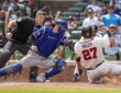 Texas Rangers catcher Kyle Higashioka, No. 11, applies a tag on sliding Atlanta Braves third baseman Austin Riley.