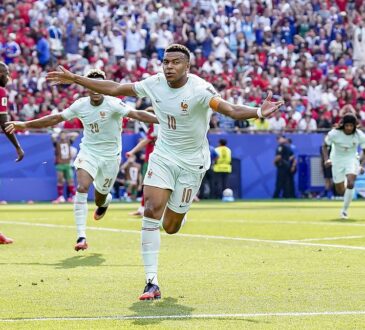 France forward Kylian Mbappé runs with both arms outstretched to celebrate against Morocco as teammates chase him.
