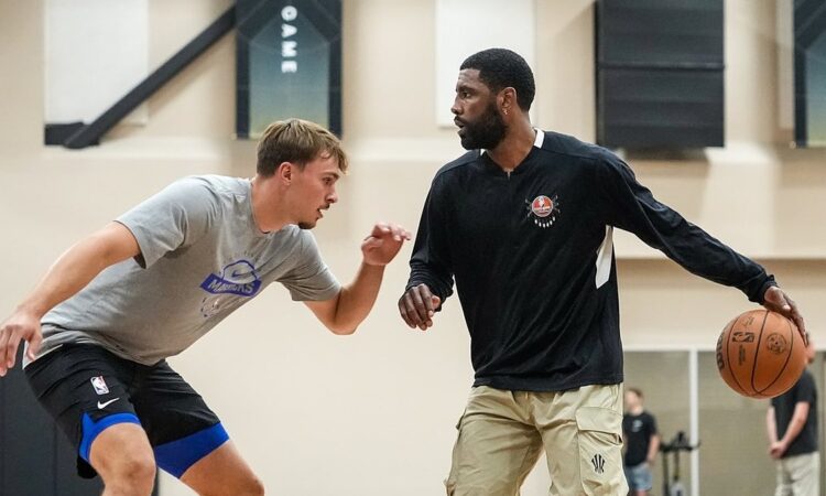 Dallas Mavericks guard Kyrie Irving dribbles to his left as forward Cooper Flagg defends during a workout.