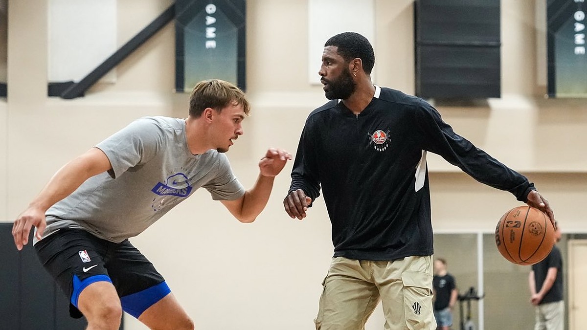 Dallas Mavericks guard Kyrie Irving dribbles to his left as forward Cooper Flagg defends during a workout.