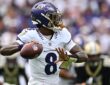 Baltimore Ravens quarterback Lamar Jackson cocks the ball back to throw with a Saints defender blurred behind him.