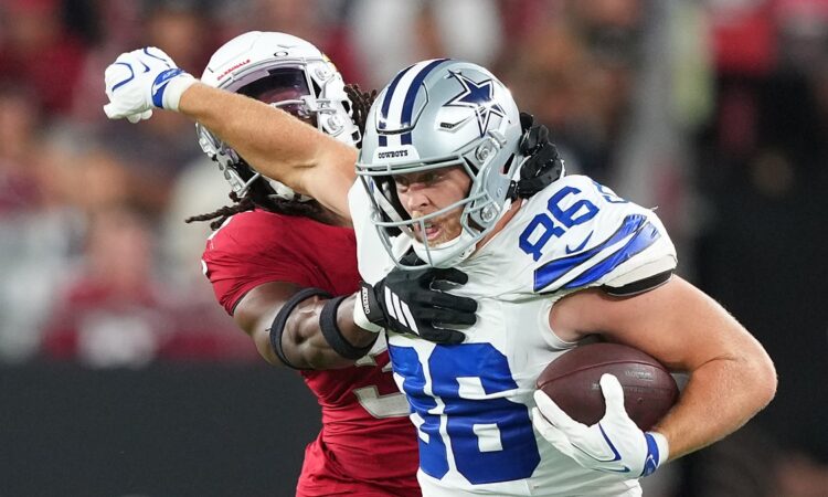 Dallas Cowboys tight end Luke Schoonmaker carries the ball as Arizona Cardinals safety Kitan Crawford wraps him up high.