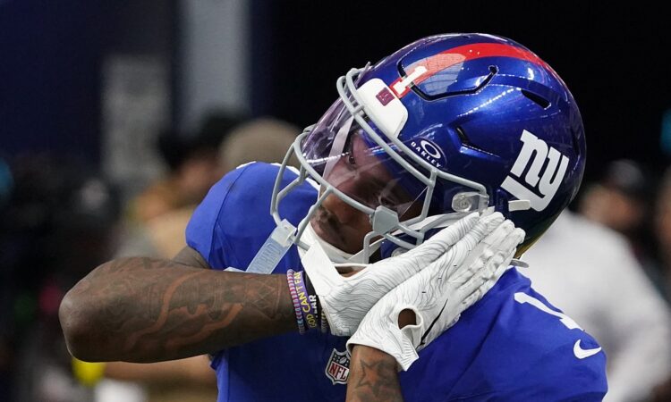 New York Giants wide receiver Malik Nabers, No. 1, brings a gloved hand to his facemask while celebrating.