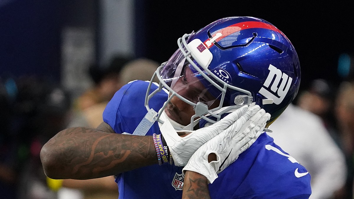 New York Giants wide receiver Malik Nabers, No. 1, brings a gloved hand to his facemask while celebrating.