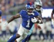 New York Giants wide receiver Malik Nabers runs upfield with the ball as a Cowboys defender pursues him.
