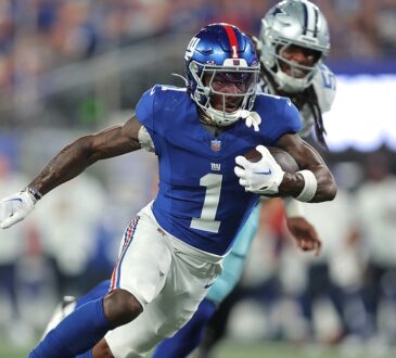 New York Giants wide receiver Malik Nabers runs upfield with the ball as a Cowboys defender pursues him.