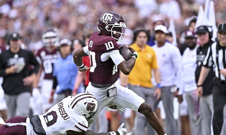 Texas A&M quarterback Marcel Reed carries the ball and escapes a diving tackle attempt by a Missouri State defender.