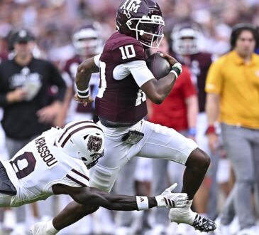 Texas A&M Aggies quarterback Marcel Reed pulls away as a diving Missouri State defender reaches for him.