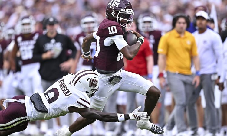 Texas A&M Aggies quarterback Marcel Reed pulls away as a diving Missouri State defender reaches for him.