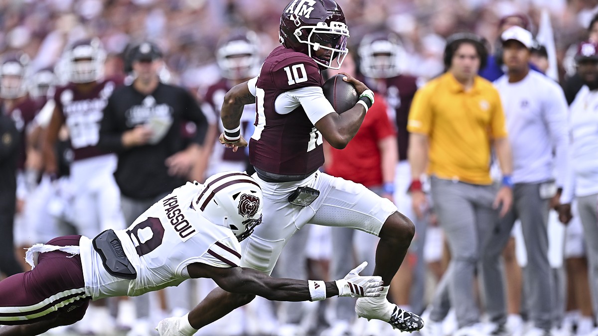 Texas A&M Aggies quarterback Marcel Reed pulls away as a diving Missouri State defender reaches for him.