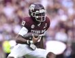 xas A&M Aggies quarterback Marcel Reed, No. 10, tucks the ball and cuts upfield.