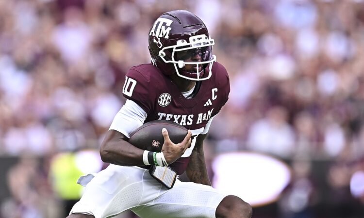 xas A&M Aggies quarterback Marcel Reed, No. 10, tucks the ball and cuts upfield.
