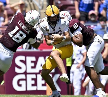 Texas A&M defensive end Marco Jones wraps up Arizona State quarterback Cutter Boley as another Aggies defender closes in.