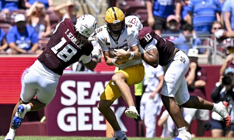 Texas A&M defensive end Marco Jones wraps up Arizona State quarterback Cutter Boley as another Aggies defender closes in.
