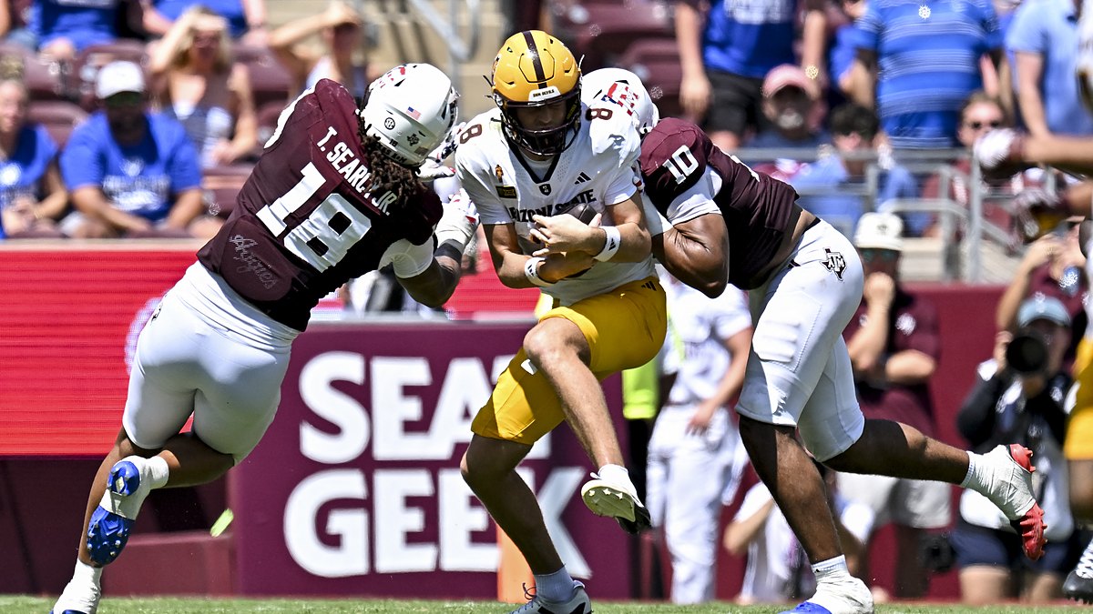 Texas A&M defensive end Marco Jones wraps up Arizona State quarterback Cutter Boley as another Aggies defender closes in.