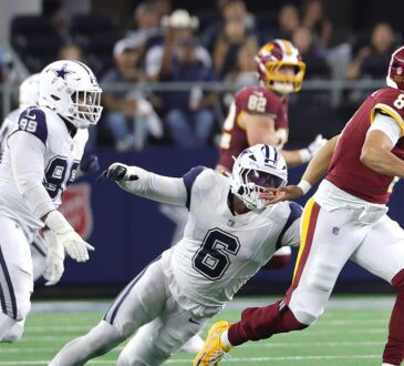 Washington Commanders quarterback Marcus Mariota scrambles as Cowboys linebacker Donovan Ezeiruaku dives after him.