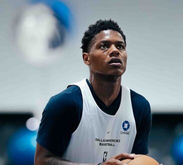 Dallas Mavericks guard Marcus Sasser looks up toward the basket in a white Mavericks practice pinny.