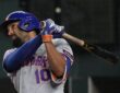 New York Mets second baseman Marcus Semien follows through on a swing as the Rangers catcher looks on.