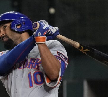 New York Mets second baseman Marcus Semien follows through on a swing as the Rangers catcher looks on.