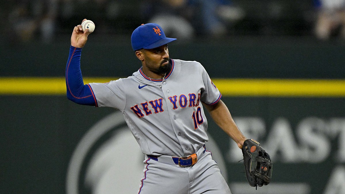 New York Mets second baseman Marcus Semien cocks his arm to make a throw in a gray Mets road uniform.