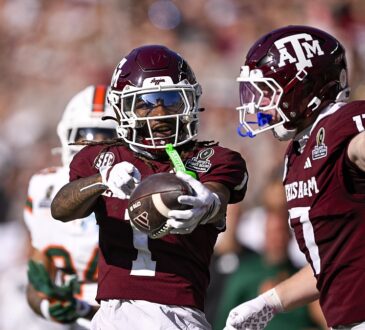 Texas A&M wide receiver Mario Craver, No. 1, holds the ball out and celebrates alongside tight end Theo Melin Ohrstrom, No. 17.