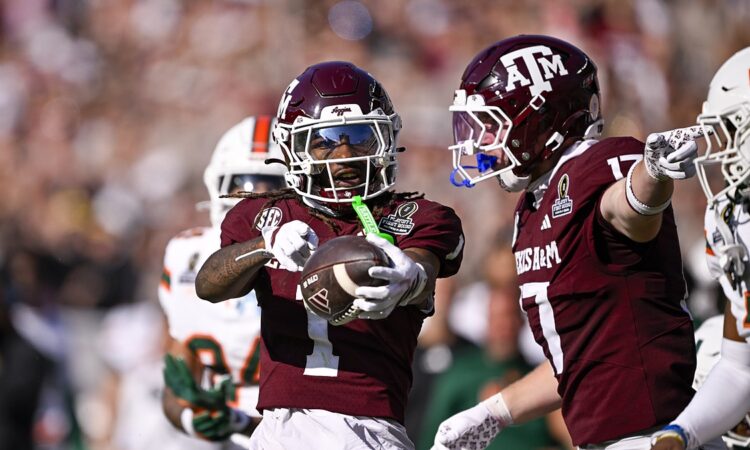 Texas A&M wide receiver Mario Craver, No. 1, holds the ball out and celebrates alongside tight end Theo Melin Ohrstrom, No. 17.