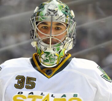 Dallas Stars goaltender Marty Turco looks on in a painted mask and white road jersey at Pepsi Center.