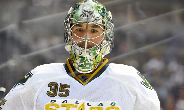 Dallas Stars goaltender Marty Turco looks on in a painted mask and white road jersey at Pepsi Center.