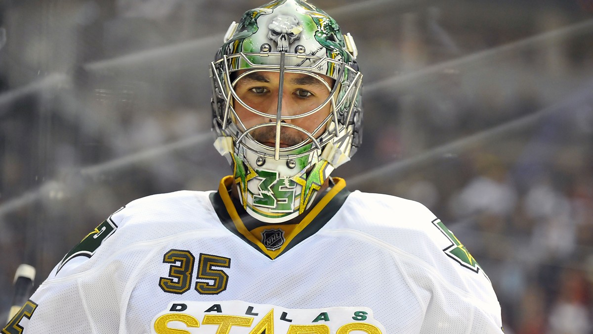 Dallas Stars goaltender Marty Turco looks on in a painted mask and white road jersey at Pepsi Center.