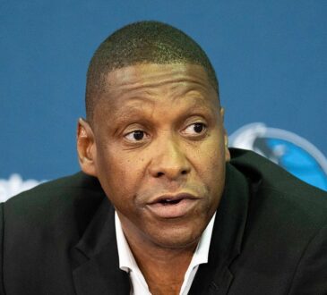 Dallas Mavericks president of basketball operations Masai Ujiri speaks at a press conference in a dark blazer.