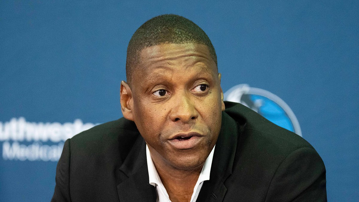 Dallas Mavericks president of basketball operations Masai Ujiri speaks at a press conference in a dark blazer.