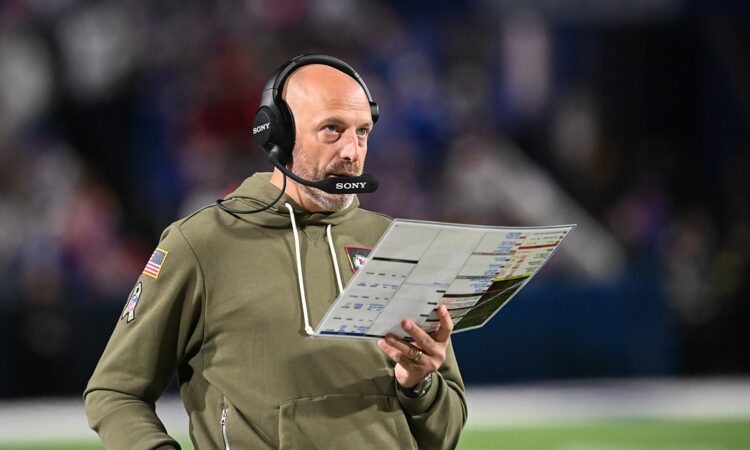 Kansas City Chiefs offensive coordinator Matt Nagy, in a headset and olive hoodie, holds a play sheet on the sideline.