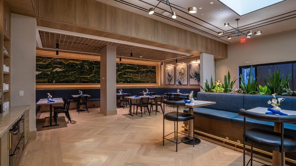 Dallas Mavericks practice facility dining room with a skylight, blue banquette seating, and a moss mural.
