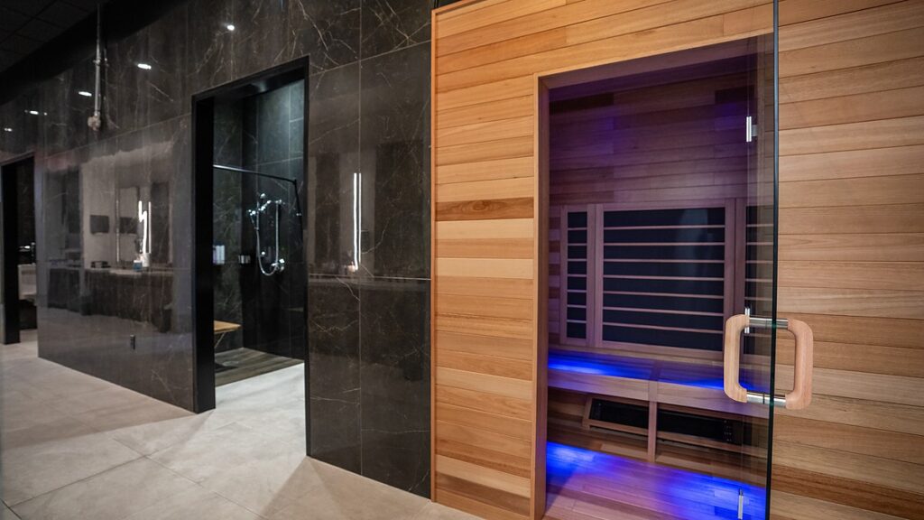 Dallas Mavericks practice facility infrared sauna with wood paneling and blue accent lighting beside a shower.