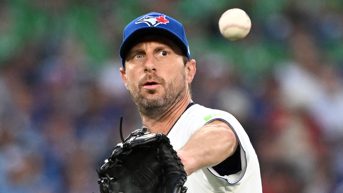 Toronto Blue Jays starting pitcher Maxwell Scherzer reaches out with his glove as a baseball flies toward him.