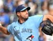 Toronto Blue Jays starting pitcher Maxwell Scherzer winds up to deliver a pitch in a light blue Blue Jays jersey.
