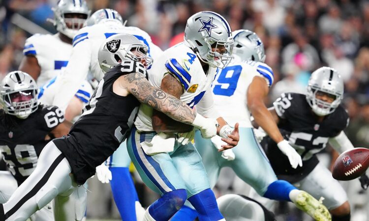 Las Vegas Raiders defensive end Maxx Crosby wraps up Dak Prescott as the ball comes loose behind them.
