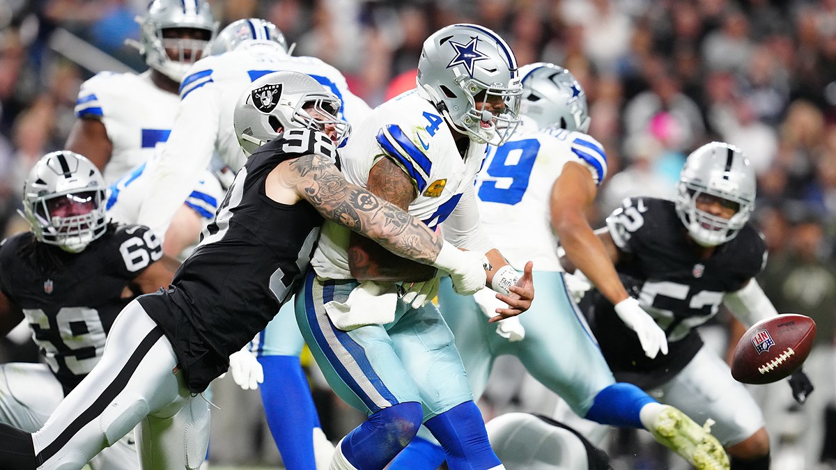 Las Vegas Raiders defensive end Maxx Crosby wraps up Dak Prescott as the ball comes loose behind them.