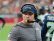 Seattle Seahawks head coach Michael Macdonald glances to his left on the sideline while wearing a headset.