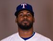 Texas Rangers pitcher Michel Otañez poses for a portrait in his home uniform against a gray backdrop.