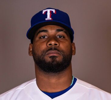 Texas Rangers pitcher Michel Otañez poses for a portrait in his home uniform against a gray backdrop.