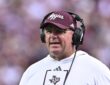Texas A&M head coach Mike Elko wears a headset on the sideline during a game.