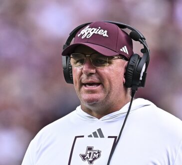 Texas A&M head coach Mike Elko wears a headset on the sideline during a game.
