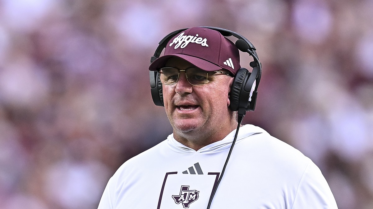 Texas A&M head coach Mike Elko wears a headset on the sideline during a game.