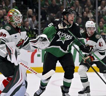Stars right wing Mikko Rantanen skates in front of Wild goaltender Jesper Wallstedt as both watch the play.